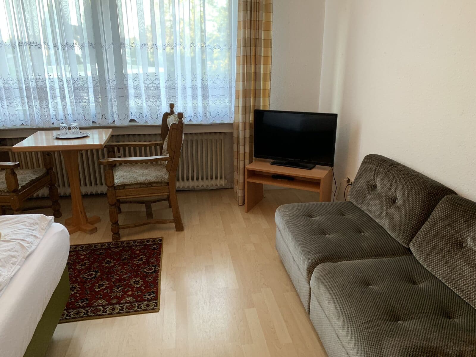 Zimmer im Hotel Jeong in Moers mit Sofa, Sitzecke und Fernseher